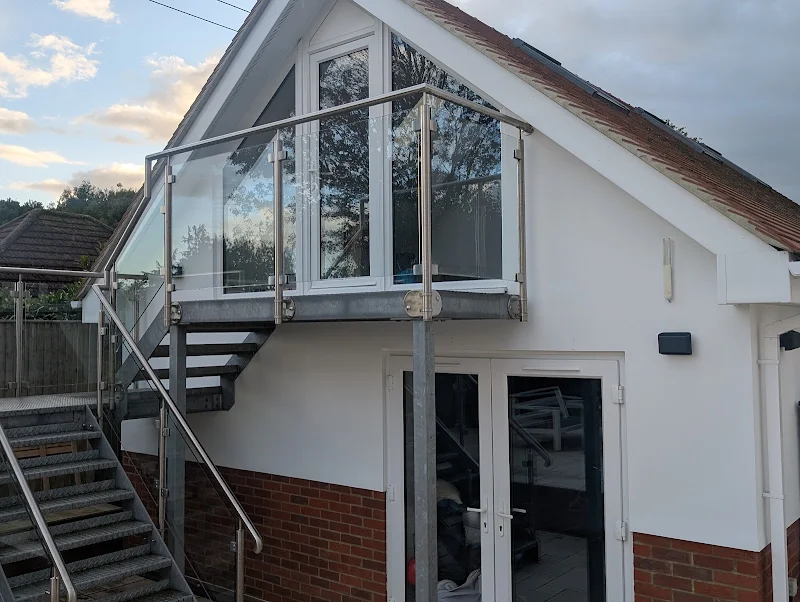 Freshly painted white render on a house exterior with glass balcony